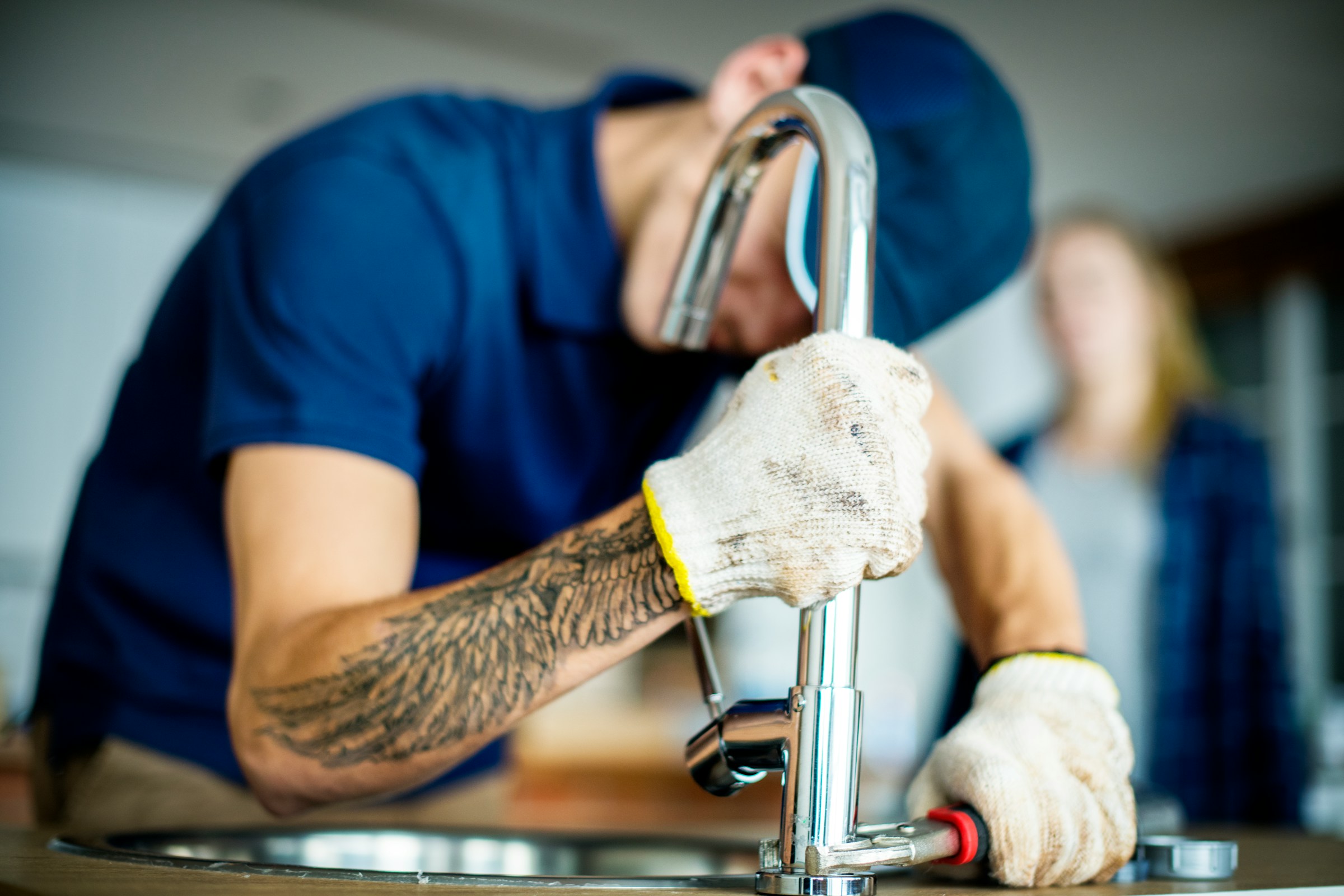 Plombier installant un robinet pour un client