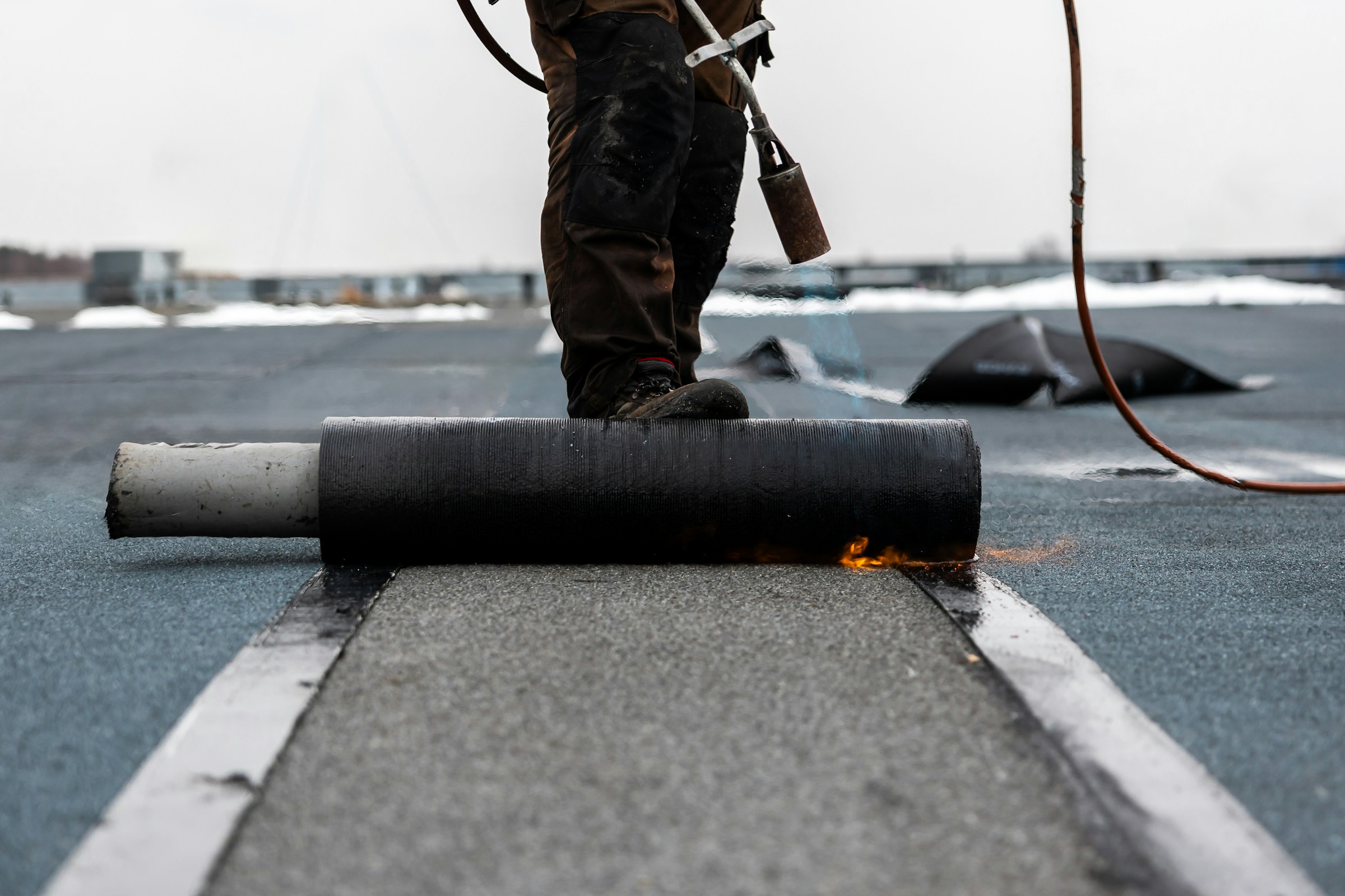 Couvreur installant une membrane de toiture